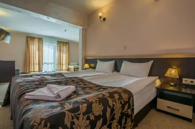 a hotel room with a large bed and a window at Hotel Royal Borovets in Borovets