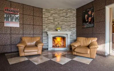 a living room with two chairs and a fireplace at Hotel Royal Borovets in Borovets
