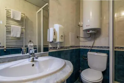 a bathroom with a sink and a toilet and a mirror at Hotel Royal Borovets in Borovets