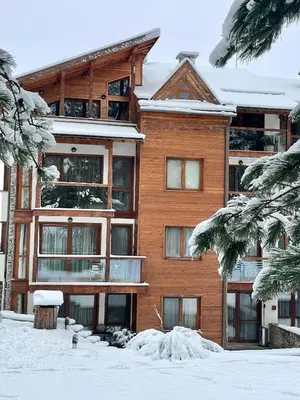 a large building with snow in front of it at Spacious penthouse chalet apartment in Pirin Golf and Country Club in Razlog