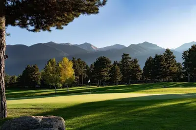 a view of a golf course with mountains in the background at Spacious penthouse chalet apartment in Pirin Golf and Country Club in Razlog