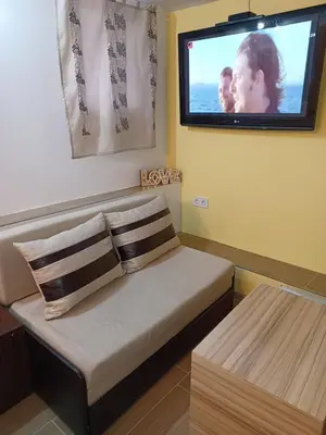 a room with a couch with a tv on the wall at Top Center Studio 5 in Sofia