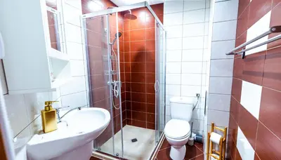 a small bathroom with a toilet and a sink at Large Stylish 2-bedroom apt near ski road, 5 min to Gondola & Bar Street in Bansko
