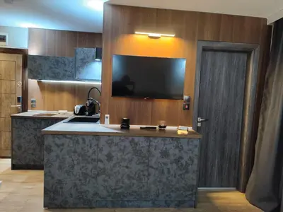 a kitchen with a large island with a tv on the wall at View apartment #2 in Bansko