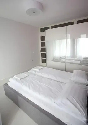 a large white bed in a room with a mirror at Modern Turquoise Apartment/free WiFi in Sofia