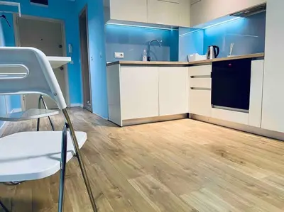 a kitchen with blue walls and a white chair in a room at Modern Turquoise Apartment/free WiFi in Sofia