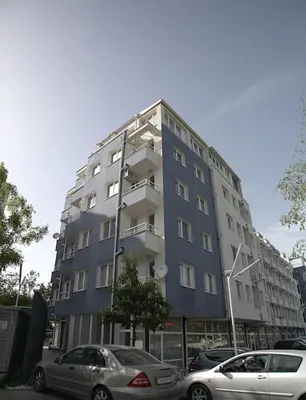 a tall building with cars parked in front of it at Modern Turquoise Apartment/free WiFi in Sofia