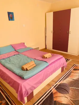 a bedroom with two beds with pink and blue sheets at Апартамент за гости Байрактарова in Smolyan