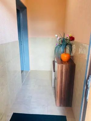 a vase of flowers sitting on a stand in a hallway at Апартамент за гости Байрактарова in Smolyan