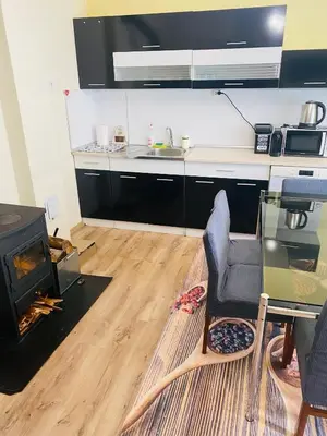 a living room with a table and a stove at Апартамент за гости Байрактарова in Smolyan