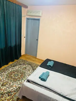 a bedroom with a bed with two blue pillows on it at Апартамент за гости Байрактарова in Smolyan