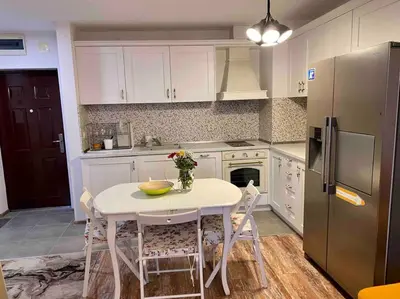 a kitchen with a white table and a refrigerator at Stylish Magenta Apartment - terrace & free parking in Sofia