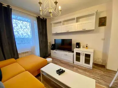 a living room with a yellow couch and a television at Stylish Magenta Apartment - terrace & free parking in Sofia