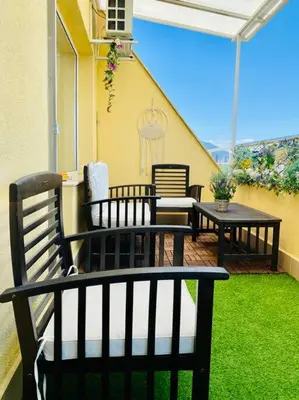 a patio with chairs and tables on a balcony at Stylish Magenta Apartment - terrace & free parking in Sofia