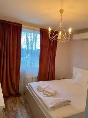 a bedroom with a bed with a chandelier and a window at Stylish Magenta Apartment - terrace & free parking in Sofia