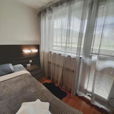 a bedroom with two beds and a window with curtains at VIP Apartments Belvedere with terrace K105 in Bansko