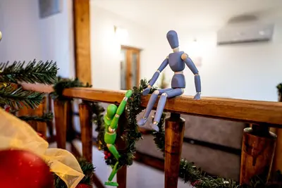 a toy man sitting on a railing with christmas decorations at Slona, Heritage Home in Old Town Plovdiv in Plovdiv