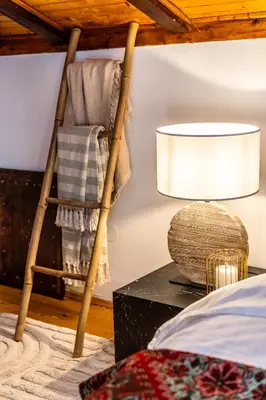 a bedroom with a rocking chair and a lamp at Slona, Heritage Home in Old Town Plovdiv in Plovdiv