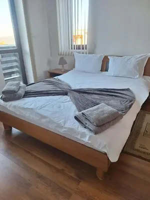 a large bed with white sheets and pillows on it at Ski Lift Apartment - Complex Gramadeto Bansko in Bansko