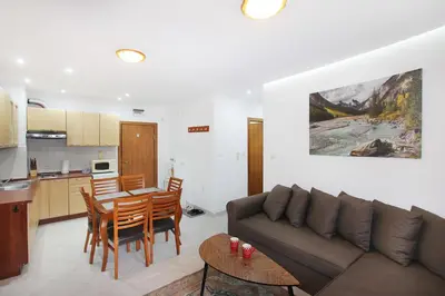 a living room and kitchen with a couch and a table at Ski Lift Apartment - Complex Gramadeto Bansko in Bansko