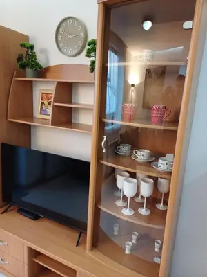 a book shelf with a tv and a clock at Ski Lift Apartment - Complex Gramadeto Bansko in Bansko