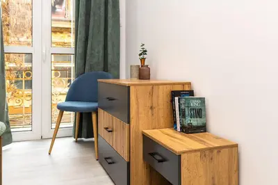 a room with a wooden dresser and a blue chair at Kapana Beat 2-bedroom apt. Top Center in Plovdiv