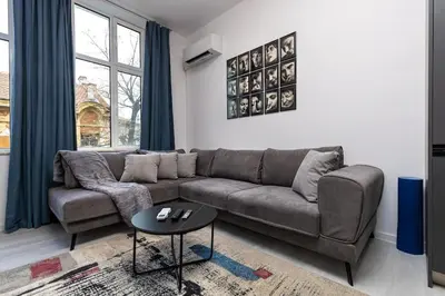a living room with a couch and a table at Kapana Beat 2-bedroom apt. Top Center in Plovdiv