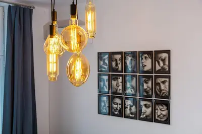 a group of lights hanging from a wall with pictures at Kapana Beat 2-bedroom apt. Top Center in Plovdiv