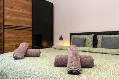 a bedroom with two beds with towels on the bed at Kapana Beat 2-bedroom apt. Top Center in Plovdiv