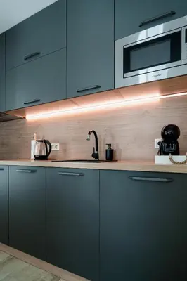 a kitchen with blue cabinets and a microwave at 8th Hill Apartments in Plovdiv