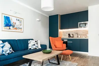 a living room with a blue couch and a table at 8th Hill Apartments in Plovdiv