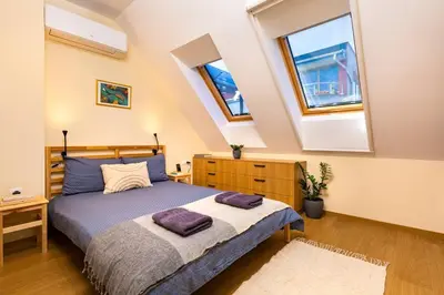 a bedroom with a bed with purple pillows on it at Hills View Central Apartment in Plovdiv
