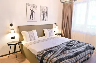 a bedroom with a bed and two posters on the wall at Marand Boutique Apartments in Bansko