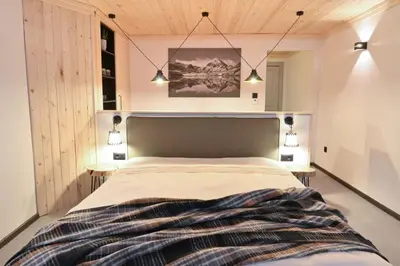 a bedroom with a large bed with two tables at Marand Boutique Apartments in Bansko
