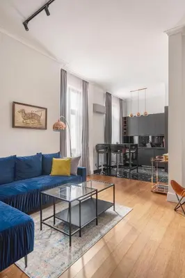 a living room with a blue couch and a table at NEW High-End 2BR Apartment with Parking in Sofia