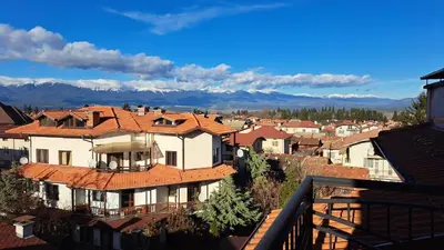 a view of a town with houses and mountains at REAL Guest House in Bansko