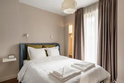 a bedroom with a bed with white sheets and a window at NEW High-End Designer 3BR Central Apt Free Parking in Sofia