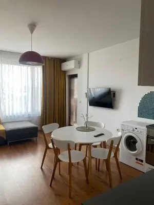a kitchen and living room with a table and chairs at Neon Gondola apartment in Bansko