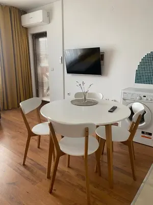 a white dining room with a white table and chairs at Neon Gondola apartment in Bansko