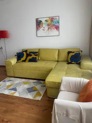 a living room with a green couch and a painting at Neon Gondola apartment in Bansko