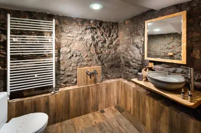 a bathroom with a sink and a stone wall at Vila Toplika in Kara Agach