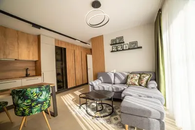 a living room with a couch and a table at ARHEYA 3 apart АРХЕЯ 3 апартамент за гости in Karlovo