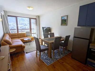 a kitchen and living room with a table and a couch at Sapphire Mountain 1 in Bansko
