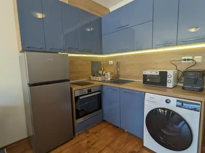 a kitchen with blue cabinets and a washing machine at Sapphire Mountain 1 in Bansko
