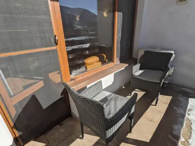 a balcony with two chairs and a table and a window at Sapphire Mountain 1 in Bansko