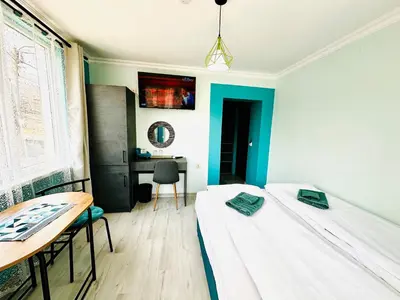 a room with two beds and a desk in it at VELI HOUSE VELINGRAD/ ВелиХаус Къща за гости Велинград in Velingrad