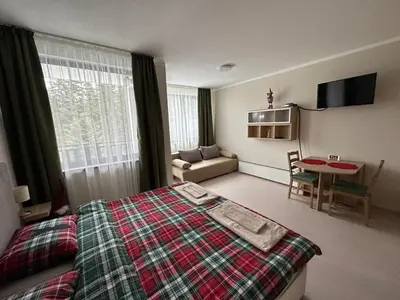 a hotel room with a bed and a living room at Borovets Gardens Funky Fresh Studio by Joro in Borovets