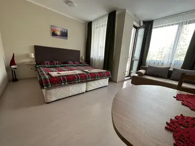 a bedroom with a bed and a table and a couch at Borovets Gardens Funky Fresh Studio by Joro in Borovets