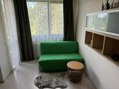 a green chair in a room with a large window at Borovets Gardens Funky Fresh Studio by Joro in Borovets
