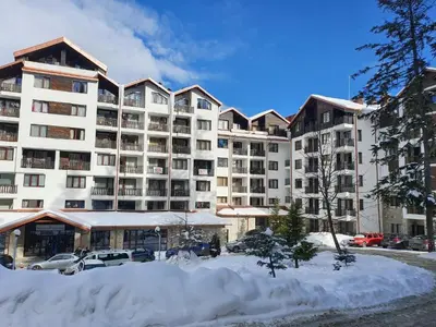 a large apartment building with snow in front of it at Borovets Gardens Funky Fresh Studio by Joro in Borovets